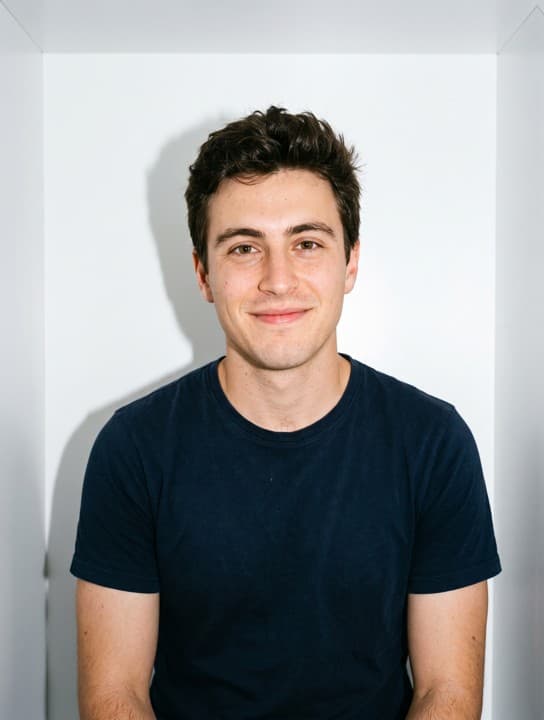 Young man in a navy t-shirt with a warm gentle smile in a photobooth